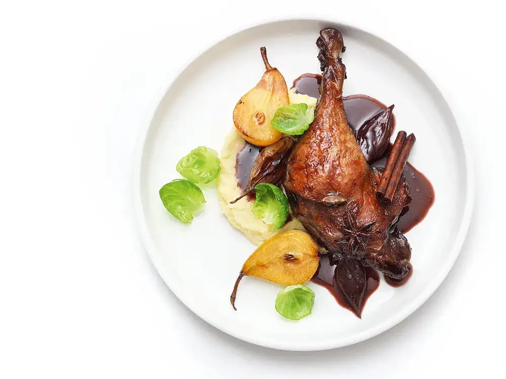 Duck legs braised in mulled wine with shallots