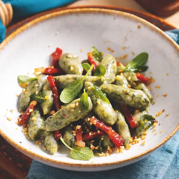 Herb gnocchi with butter, speck, and chopped hazelnuts