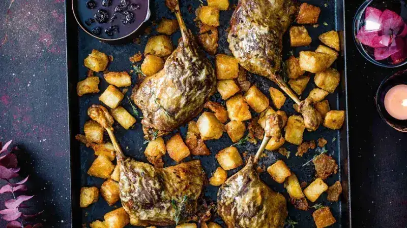 Pato asado con patatas crujientes y salsa de cerezas ácidas y vino caliente