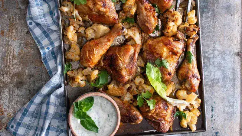 Chicken baked on a baking sheet with cauliflower