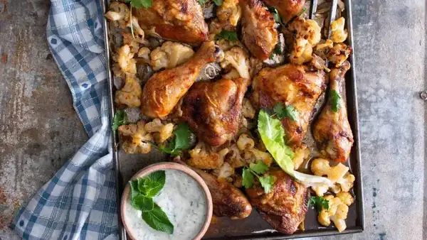 Chicken baked on a baking sheet with cauliflower