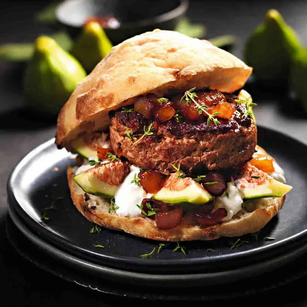 Beef burger with figs, stracciatella cheese, and caramelized onions