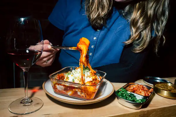 Pasteles de arroz coreanos al estilo ziti horneados y banchan en un nuevo bar de vinos