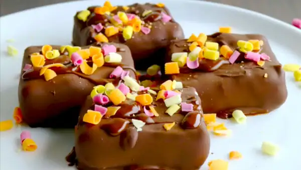 Cheesecake bites with strawberries and a chocolate coating: This sweet finger food is made without baking in the refrigerator