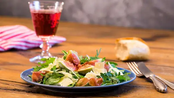 Late summer salad for gourmets: rocket salad with figs, mozzarella and Parmesan cheese