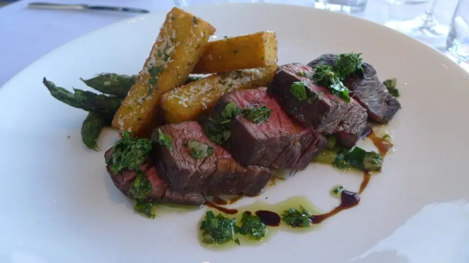 Bistec estilo bistró con papas fritas de polenta y salsa verde.
