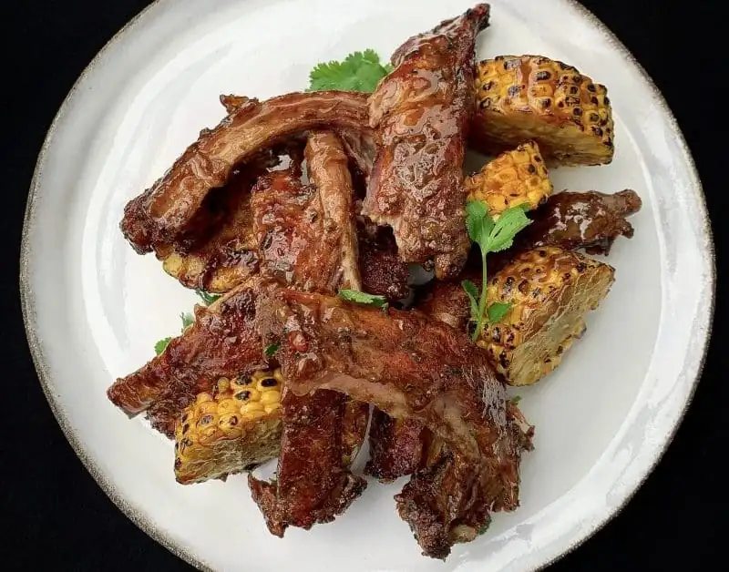 Costillas de cerdo tiernas que se deshacen en la boca, acompañadas de maíz jugoso y cilantro