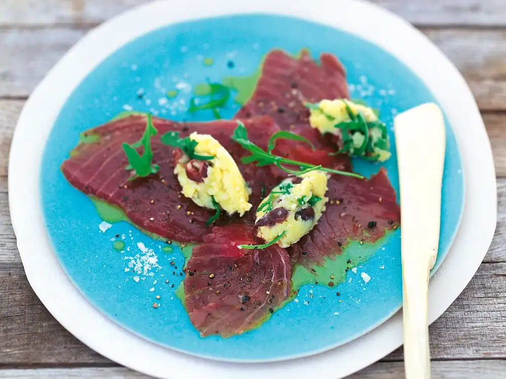 Marinated tuna with smashed potatoes, olives and arugula