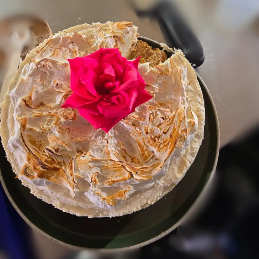 Tarta de queso con limón, lima, ron y coco, acompañada de crema de malvavisco