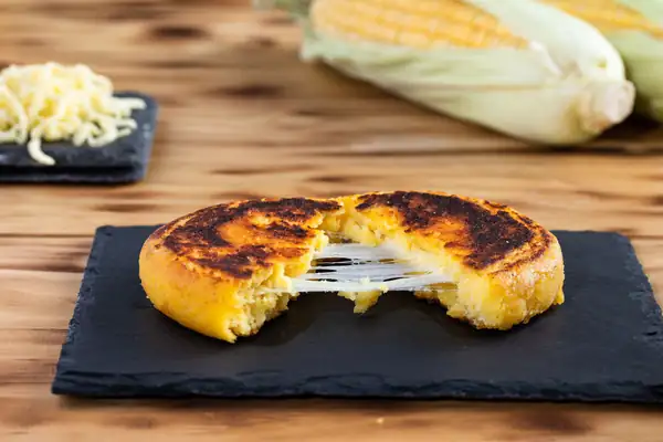 La arepa, alimento venezolano de raíces precolombinas que sigue en la mesa