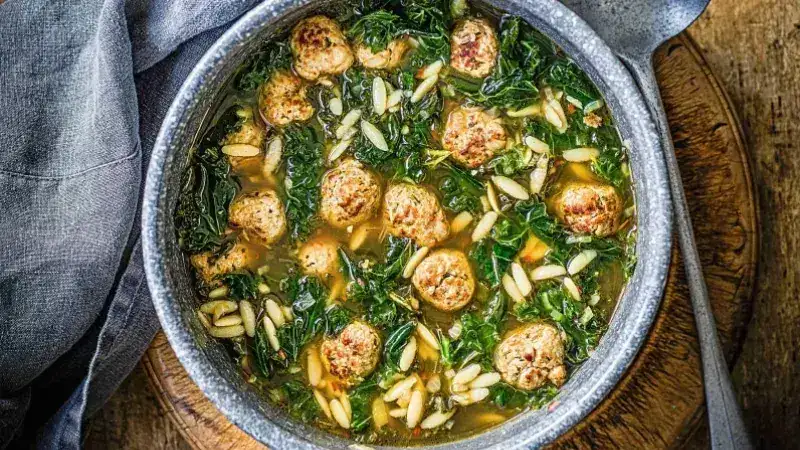Hearty soup with kale and meatballs